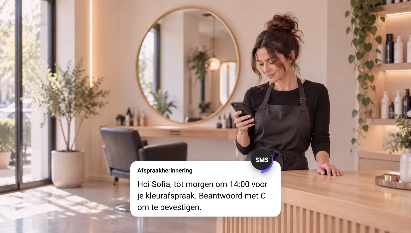 Saloneigenaar leest een sms-herinnering voor een afspraak op haar telefoon