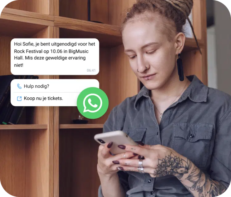 Meisje met een tatoeage die op haar telefoon kijkt of ze een uitnodiging voor een rockfestival heeft ontvangen via WhatsApp