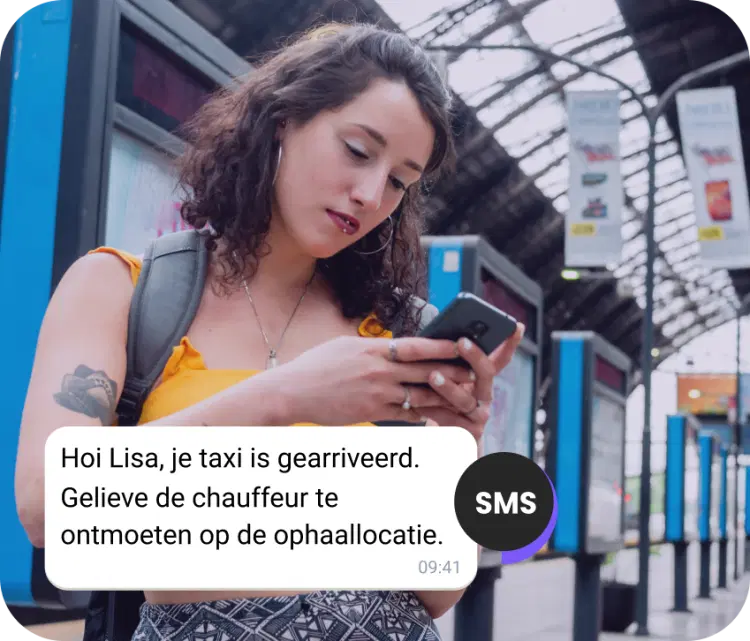 Meisje met een rugzak op het station dat een sms controleert over haar aankomende taxi
