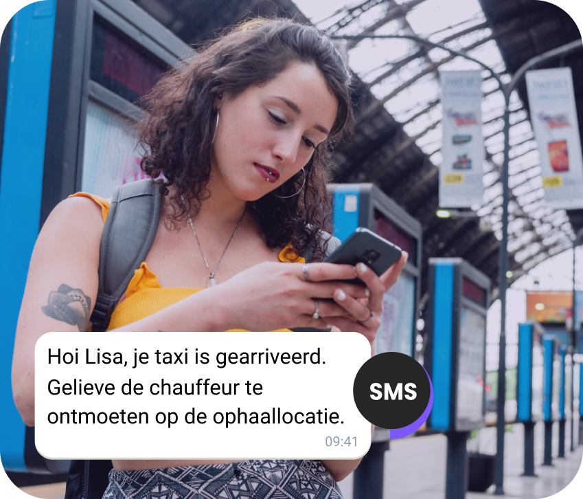 Meisje met een rugzak op het station leest een SMS over haar taxi die eraan komt