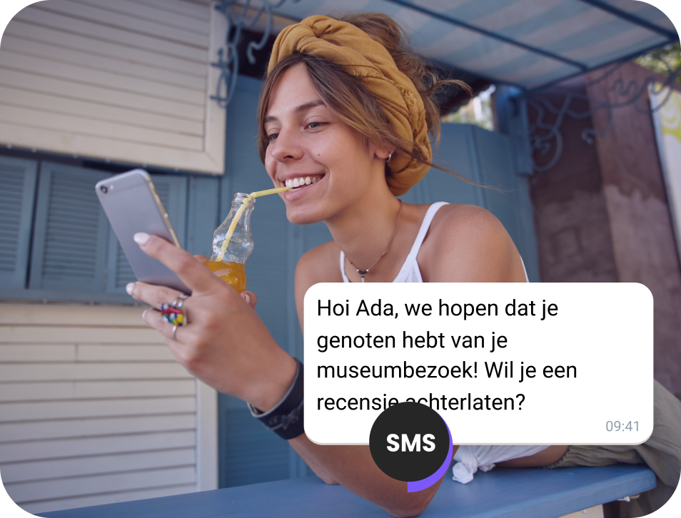 Meisje drinkt sap op straat en leest een SMS-bevestiging voor een concertticket